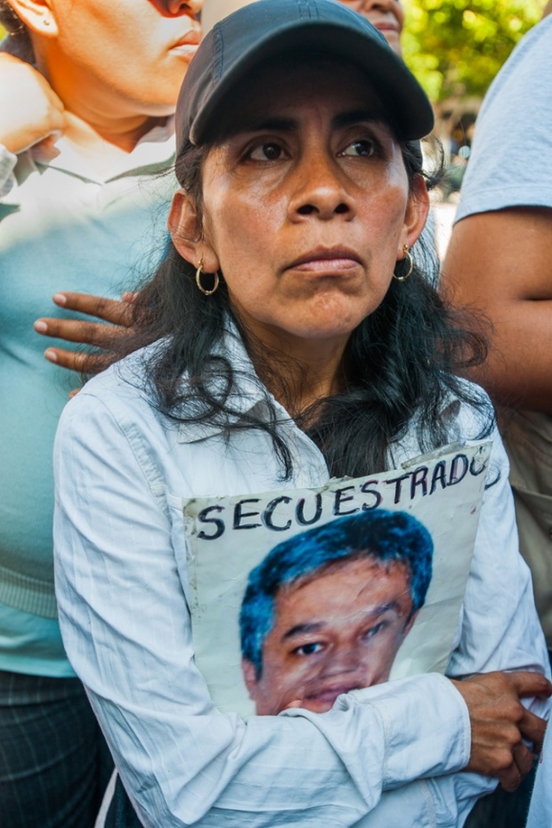 An unidentified woman carries a picture of a family member with the word ‘Kidnapped’ in Spanish. Photograph: Keith Dannemiller/for the Guardian